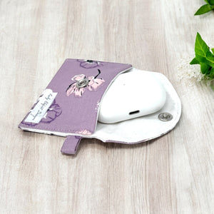 AirPods in a purple flower pouch with snap closure