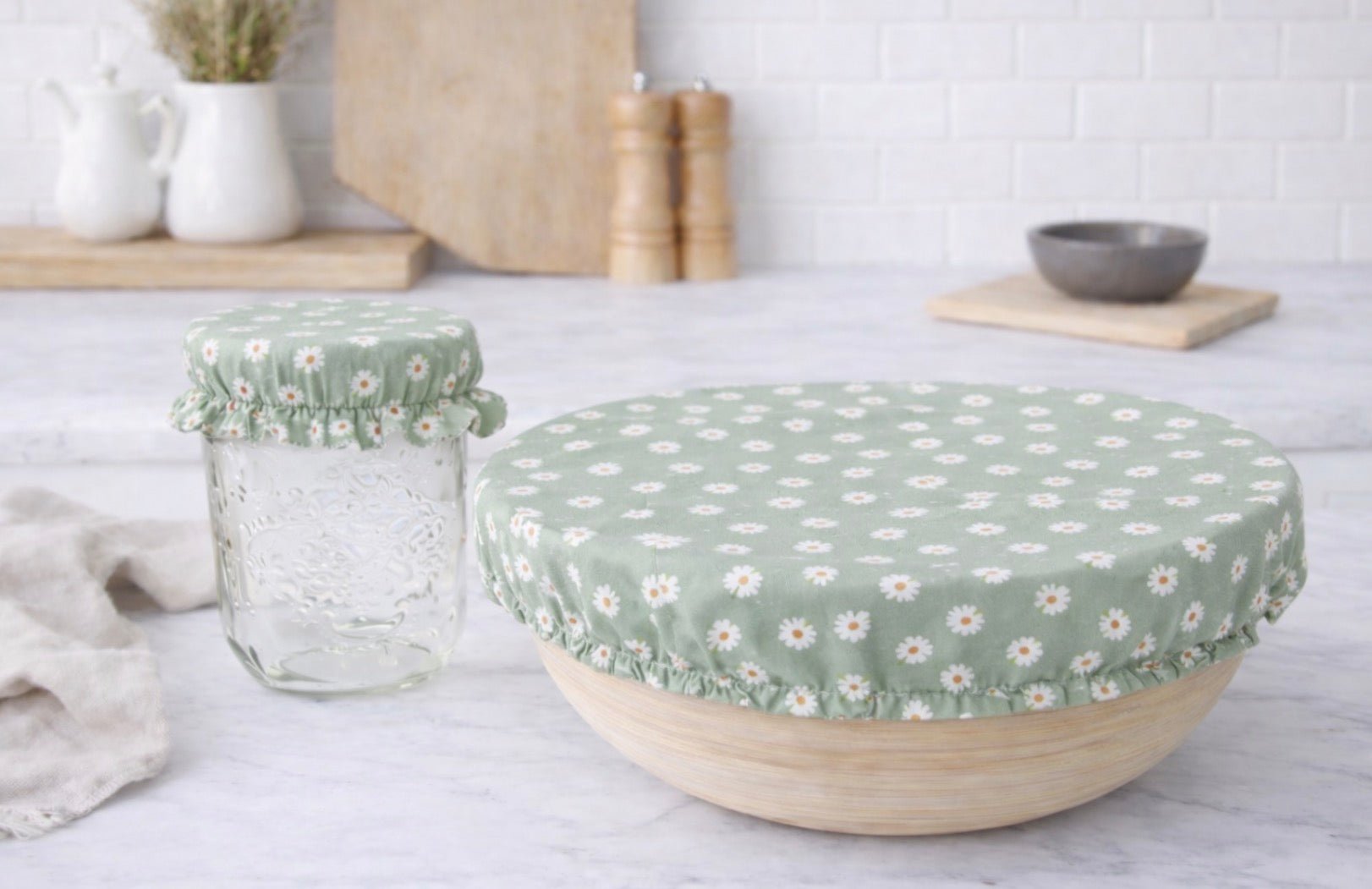 Green daisy print reusable bowl cover on bowl and jar, sustainable fabric food cover for kitchen storage