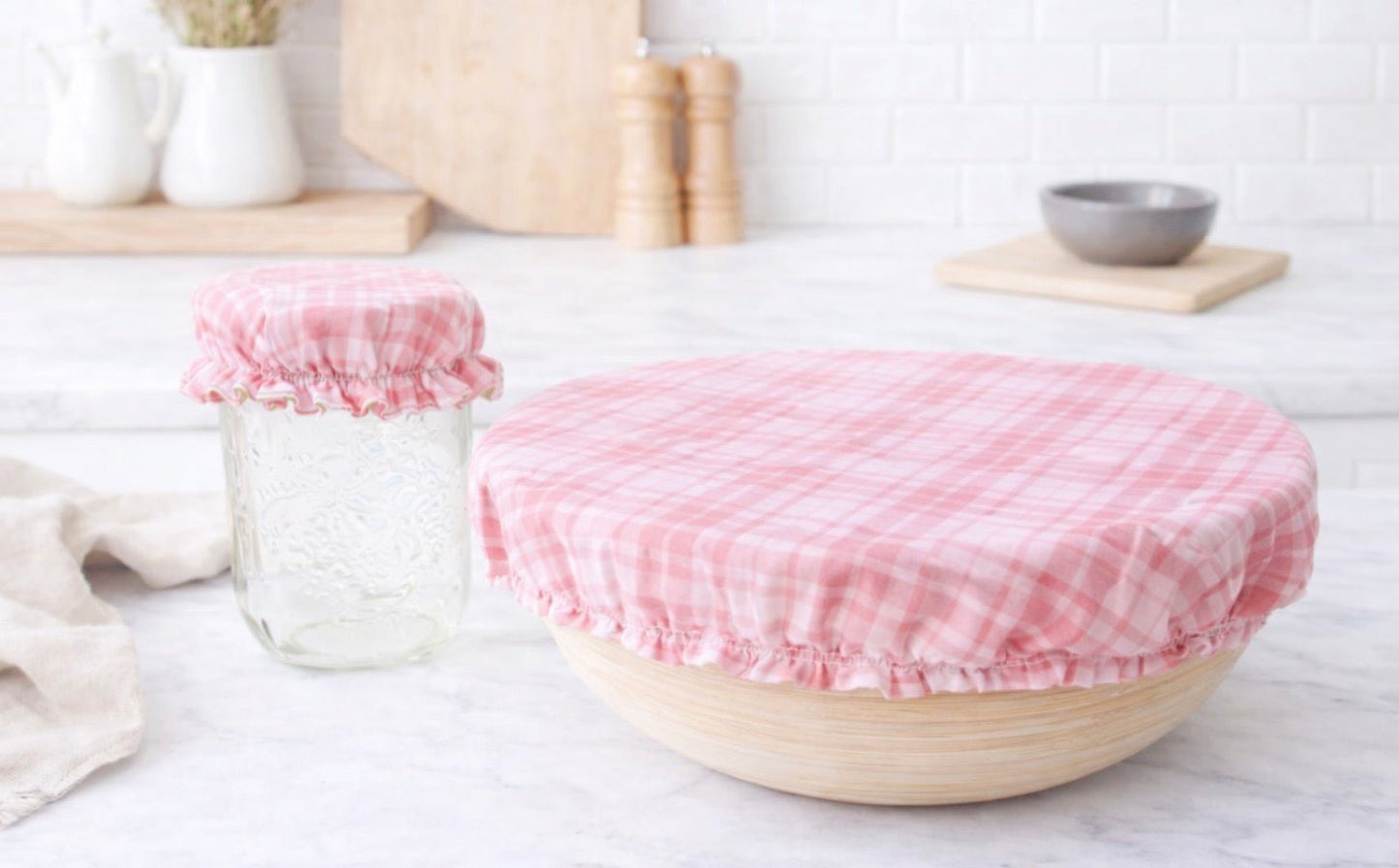 Pink gingham reusable fabric bowl cover on bowl and jar, washable eco-friendly food cover for kitchen storage