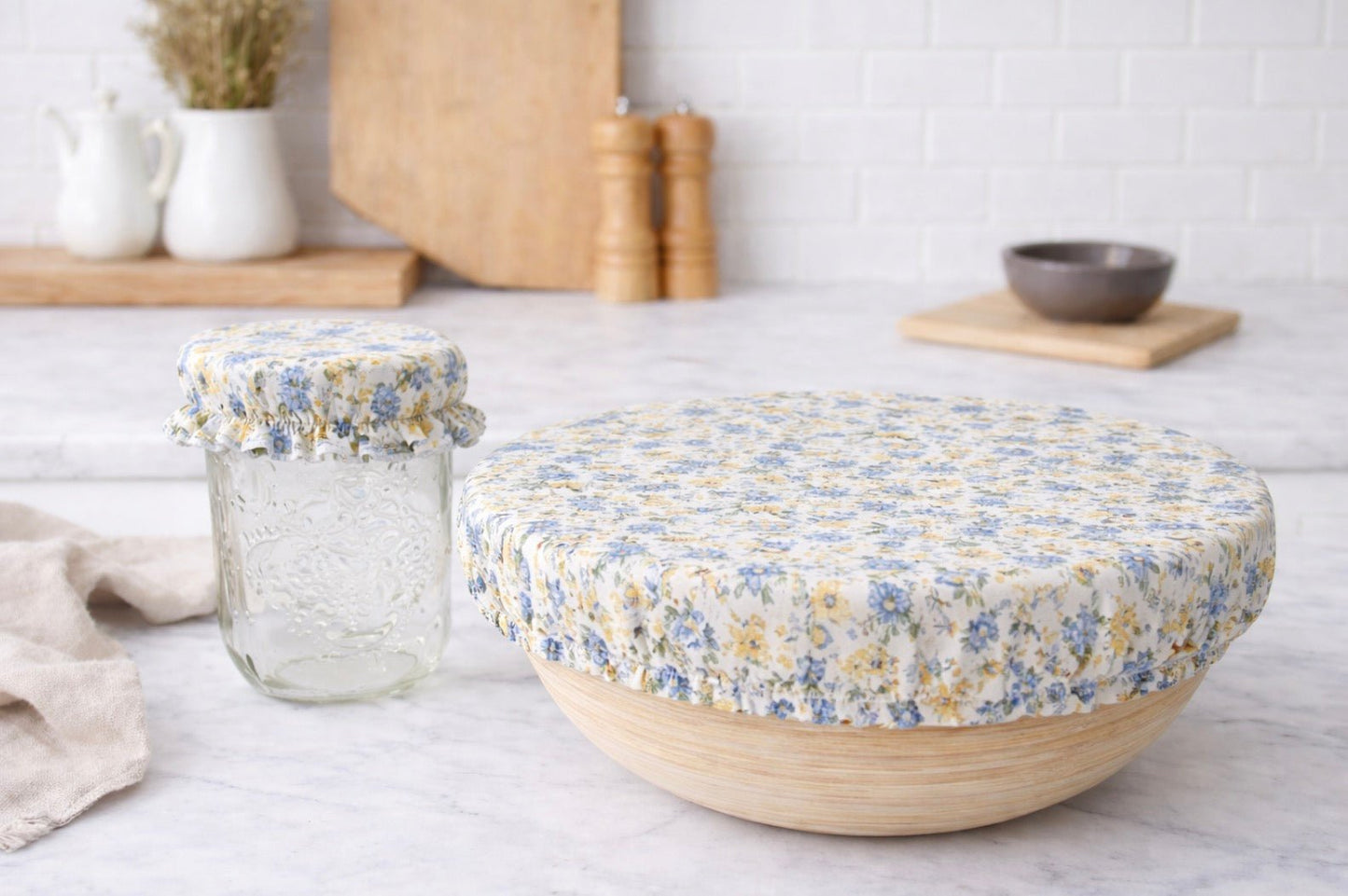 Yellow and blue floral reusable bowl cover on bowl and jar, washable fabric cover for food storage in kitchen