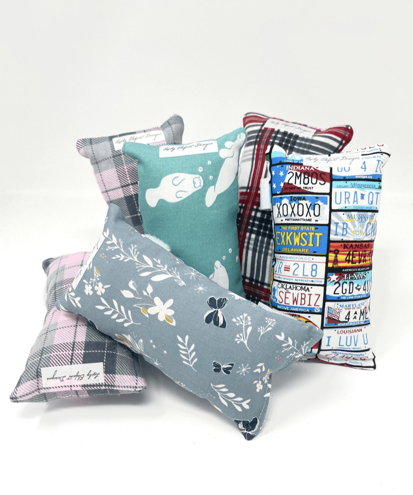 Handmade chemo port pillows in various fabric patterns including floral plaid and novelty prints for comfort