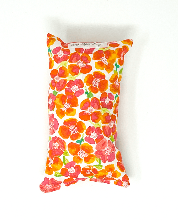 Orange floral chemo port pillow designed to cushion chest port and reduce seatbelt pressure during car rides and recovery