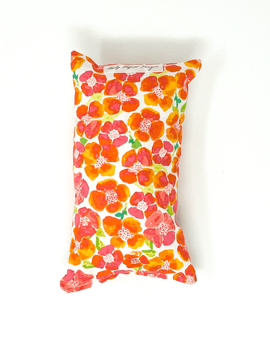 Orange floral chemo port pillow designed to cushion chest port and reduce seatbelt pressure during car rides and recovery